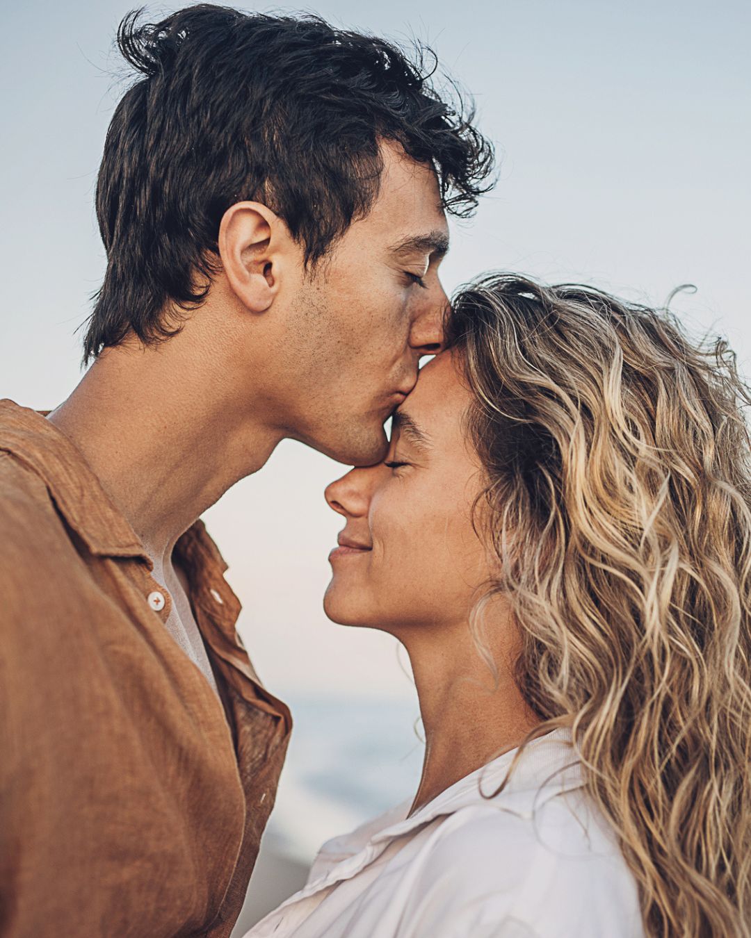 Ein Mann küsst seine Frau auf die Stirn. Beziehungen und Selbstwert.