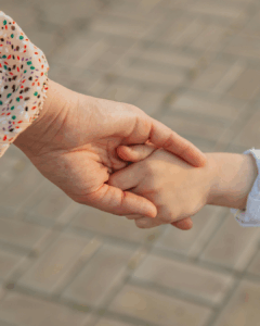 Ein Erwachsener hält die Hand eines Kindes – symbolisch für die Verbindung zum inneren Kind und emotionale Selbstfürsorge.