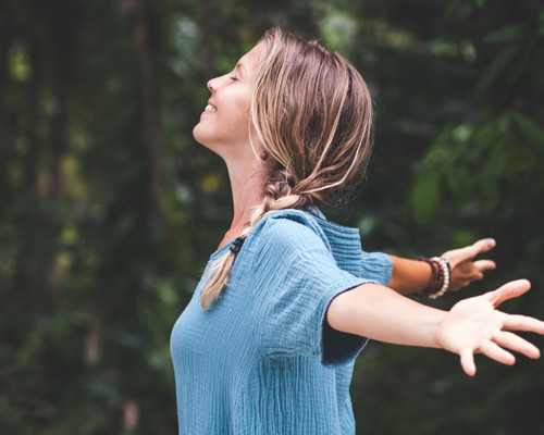 Titelbild des Kurses Unterbewusstsein stärken. Darauf ist eine Frau zu sehen, die ihre Arme nach hinten ausstreckt und lächelt.