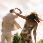 Paar tanzt auf einer Wiese im weichen Sonnenlicht