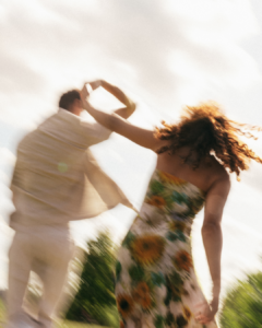 Paar tanzt auf einer Wiese im weichen Sonnenlicht