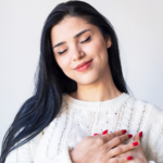 Frau mit geschlossenen Augen und Hand auf dem Herzen als Symbol für innere Ruhe, Selbstfürsorge und Gelassenheit – Kontrolle loslassen, Emotionen regulieren und die ‚Lass sie doch‘-Theorie im Alltag umsetzen.